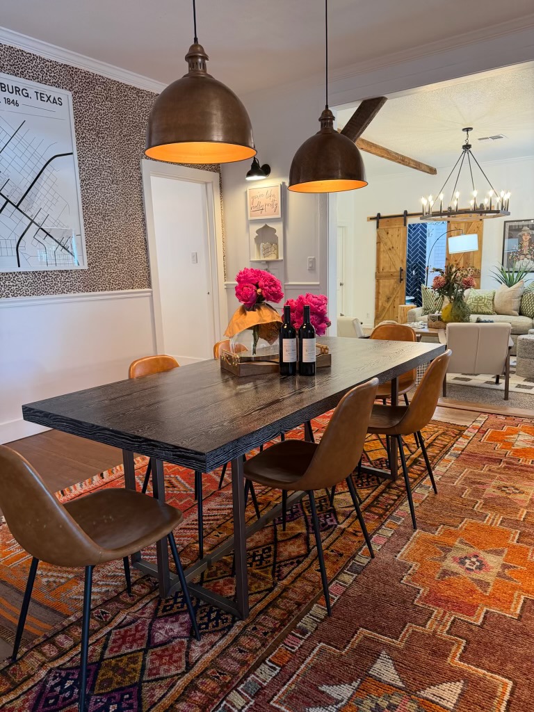 Poplar Place dining room with a long dark wood table, leather chairs, bronze pendants, and a Fredericksburg, Texas map on the wall.
